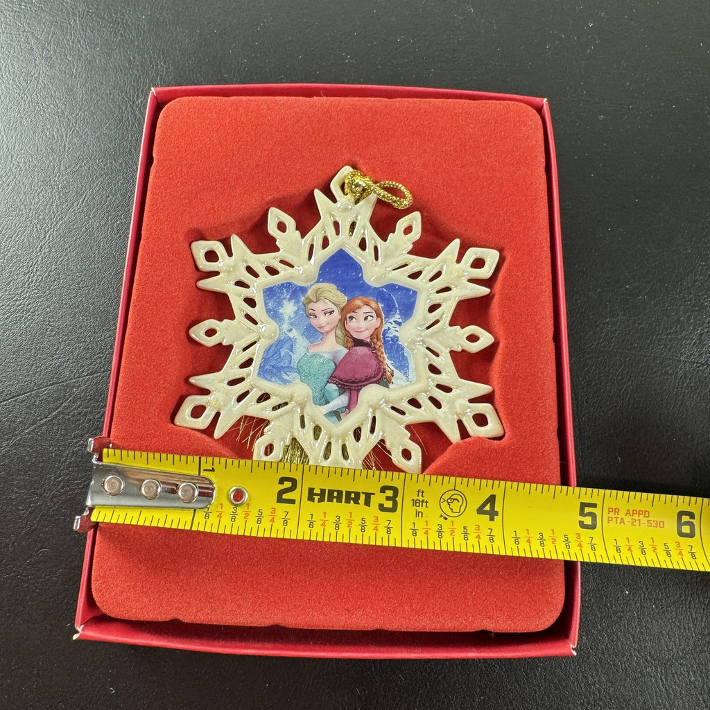 Lenox Disney Showcase Frozen Elsa and Anna fine porcelain snowflake Christmas ornament with gold tassel.