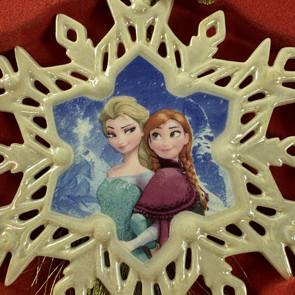 Lenox Disney Showcase Frozen Elsa and Anna fine porcelain snowflake Christmas ornament with gold tassel.