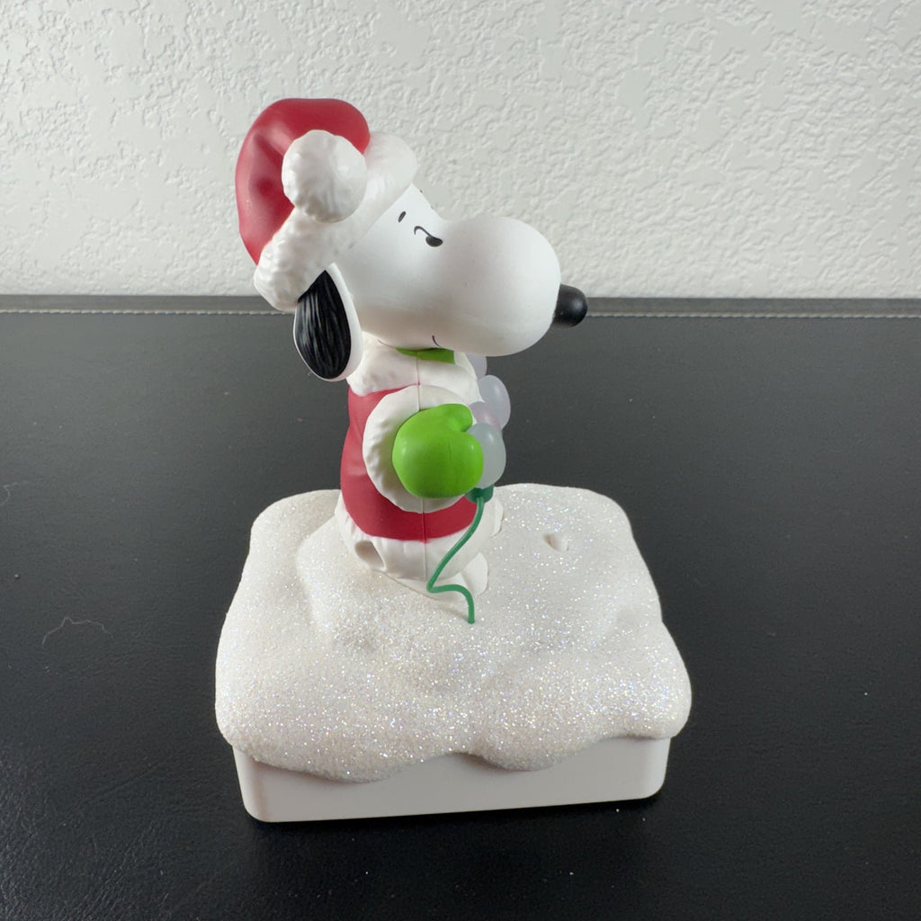 Hallmark Snoopy in Santa suit holding holiday lights on a glittery snow base tabletop figure