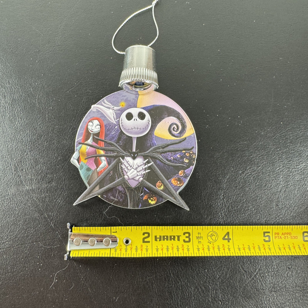 Disney Nightmare Before Christmas LED light-up clear acrylic disc ornament featuring Jack Skellington and Sally.