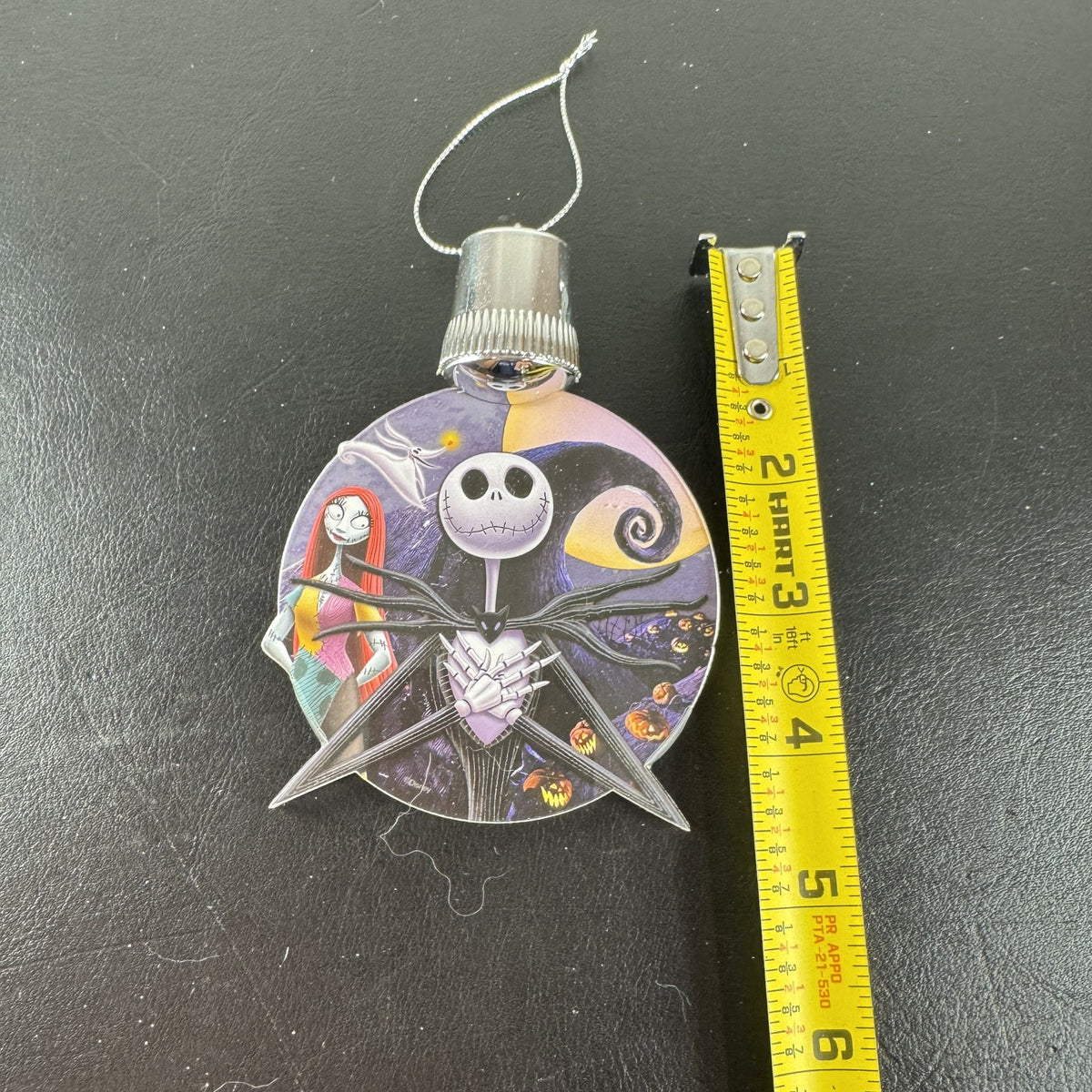 Disney Nightmare Before Christmas LED light-up clear acrylic disc ornament featuring Jack Skellington and Sally.