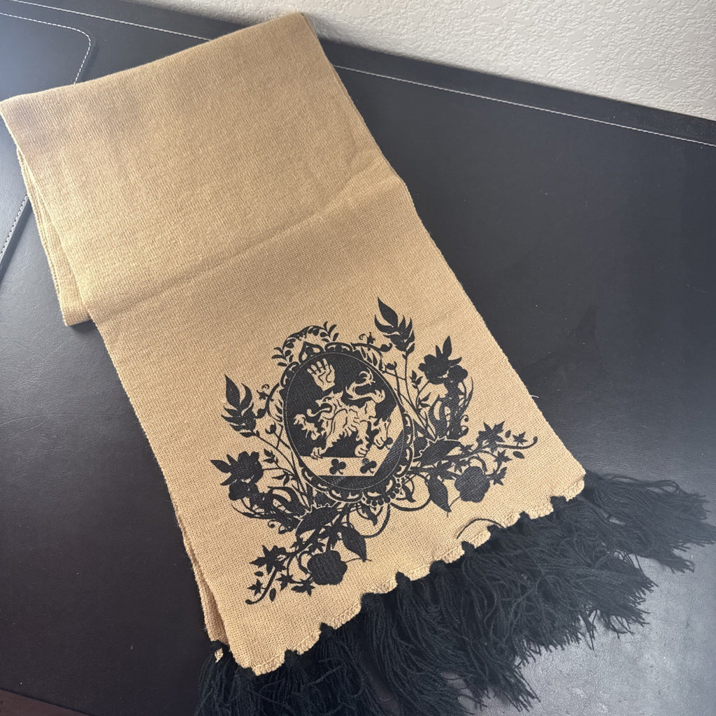 Tan knit Twilight Saga New Moon promo scarf featuring the Cullen family crest and black fringe tassels.