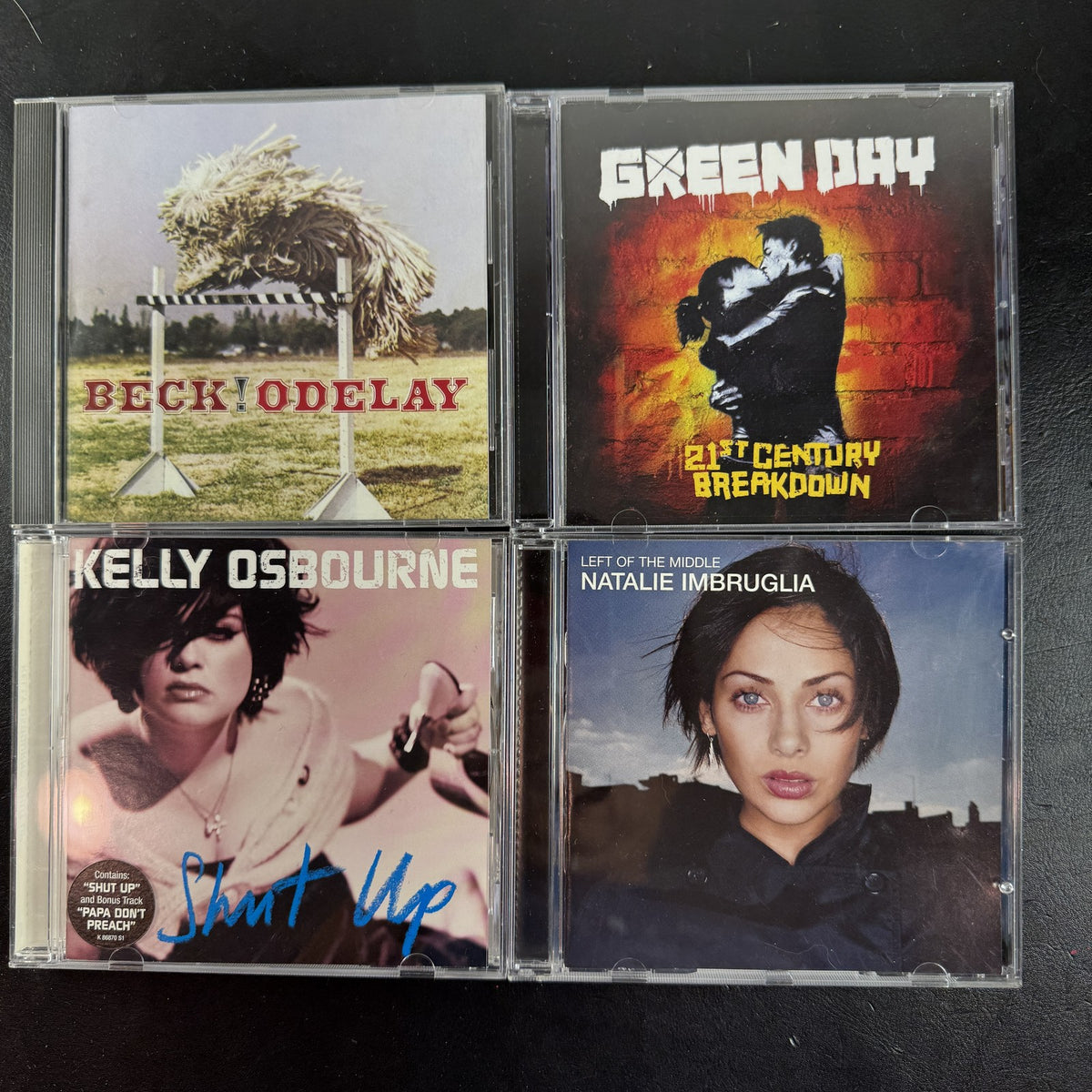 4 CD album lot featuring Beck Odelay, Green Day 21st Century Breakdown, Natalie Imbruglia, and Kelly Osbourne CDs