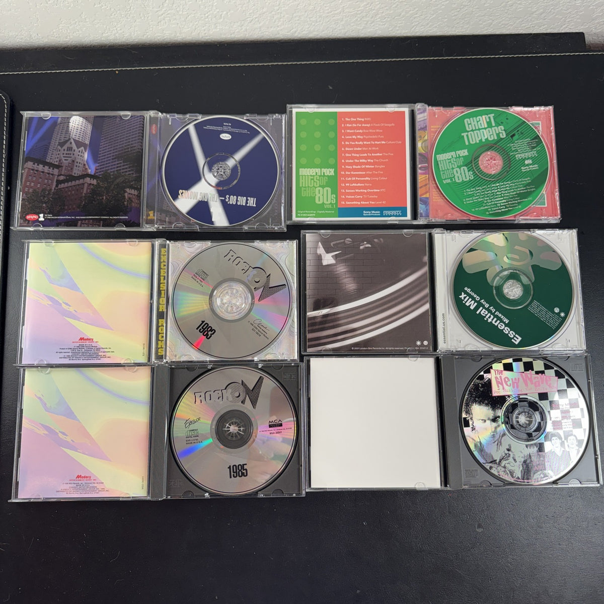 Set of 6 pre-owned 1980s compilation CDs including 80s movie hits and new wave rock collections.