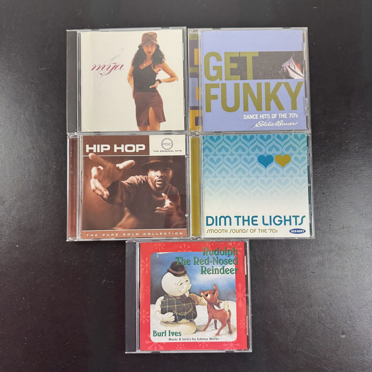 Set of 5 pre-owned music CDs including Mýa album, Burl Ives Rudolph, and 70s compilation albums.