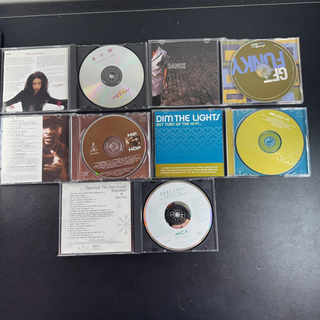 Set of 5 pre-owned music CDs including Mýa album, Burl Ives Rudolph, and 70s compilation albums.