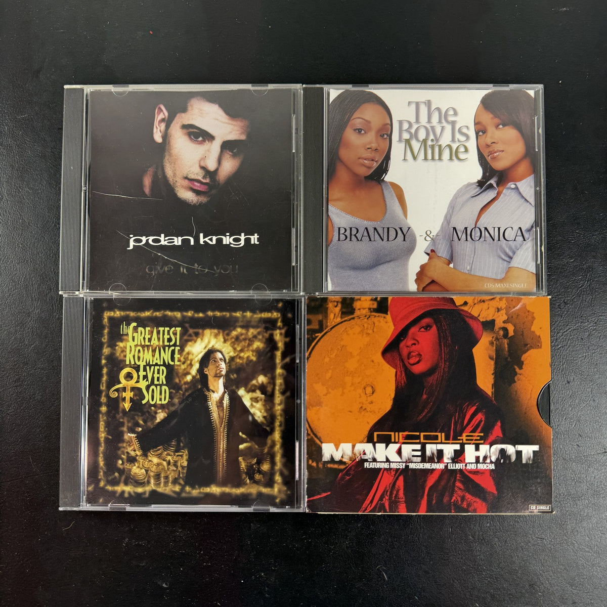 Lot of four late 90s R&B and pop CD singles featuring Brandy and Monica, Prince, Jordan Knight, and Nicole.