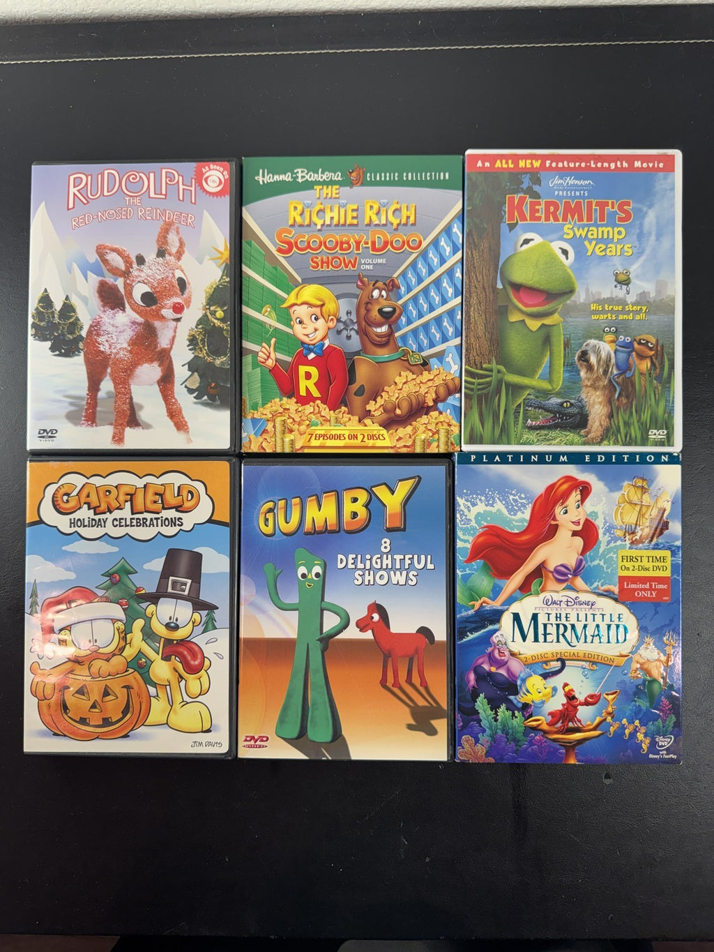 Collection of 6 family animation DVDs including Disney's The Little Mermaid, Scooby-Doo, and Garfield in cases.
