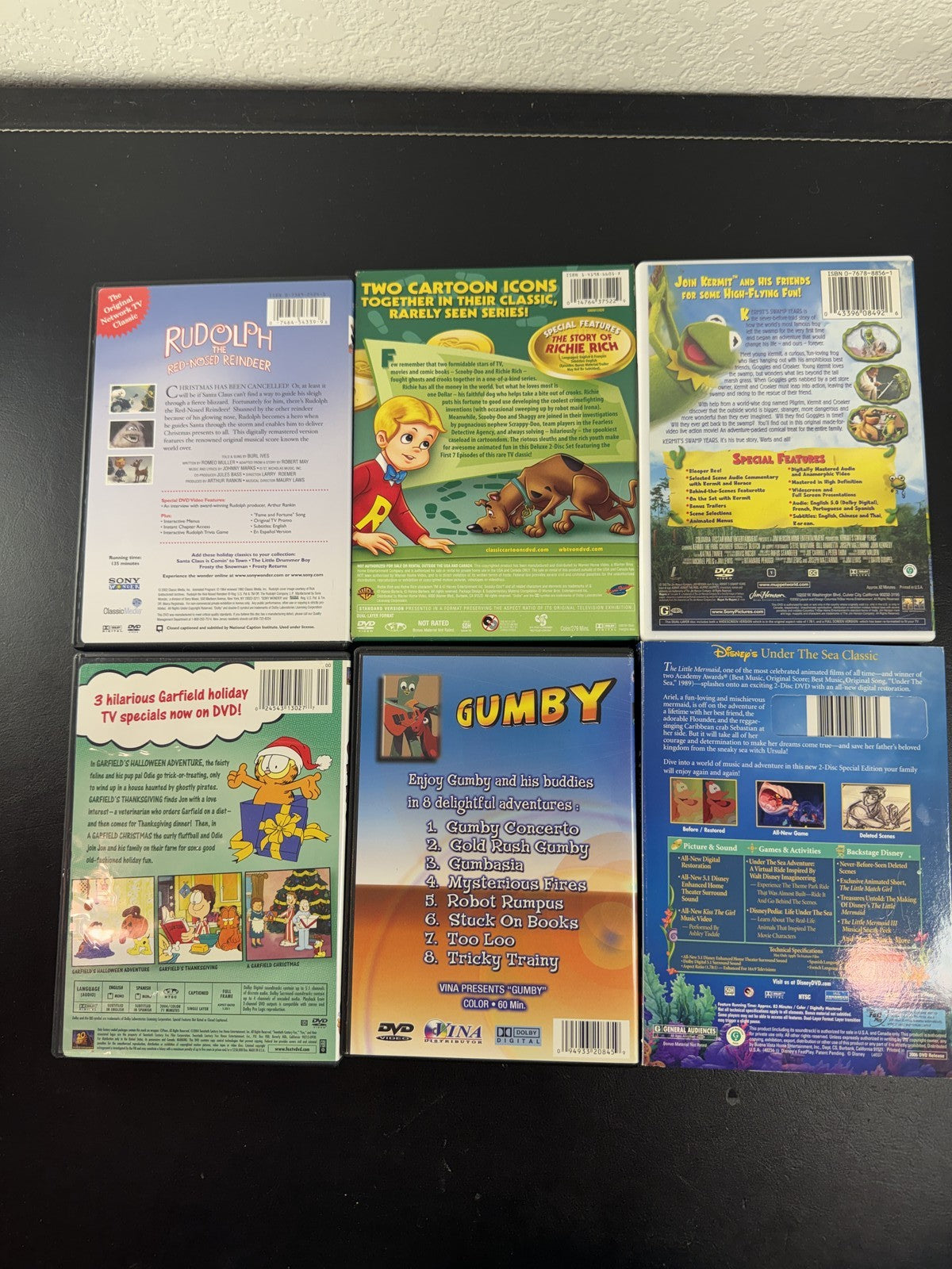Collection of 6 family animation DVDs including Disney's The Little Mermaid, Scooby-Doo, and Garfield in cases.