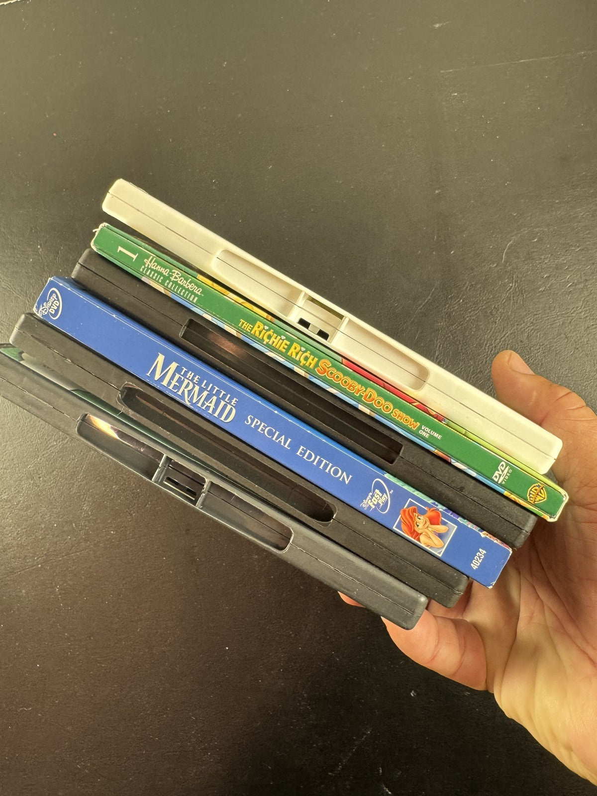 Collection of 6 family animation DVDs including Disney's The Little Mermaid, Scooby-Doo, and Garfield in cases.