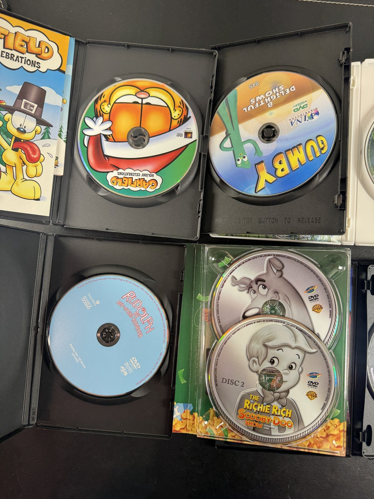 Collection of 6 family animation DVDs including Disney's The Little Mermaid, Scooby-Doo, and Garfield in cases.