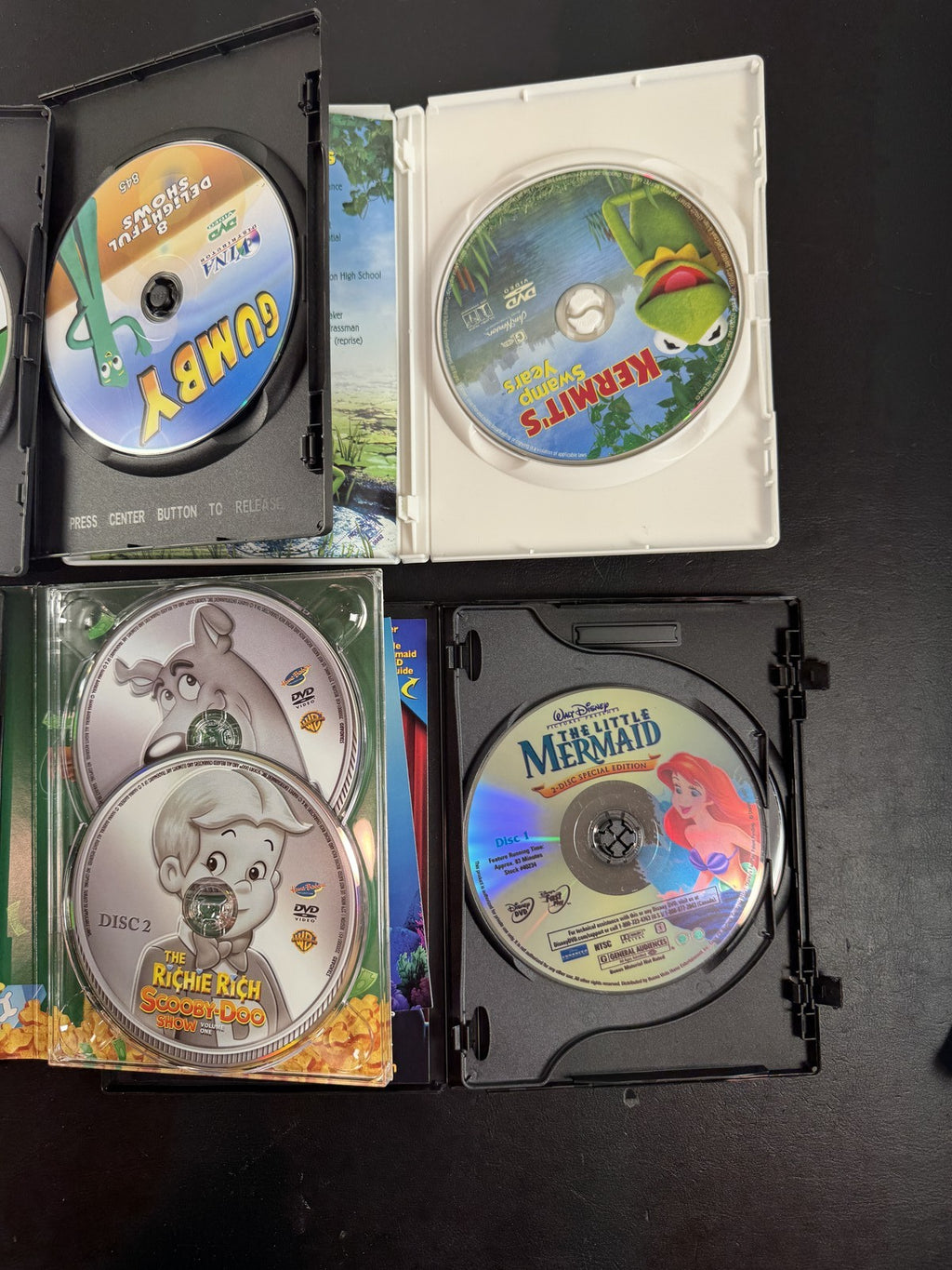 Collection of 6 family animation DVDs including Disney's The Little Mermaid, Scooby-Doo, and Garfield in cases.