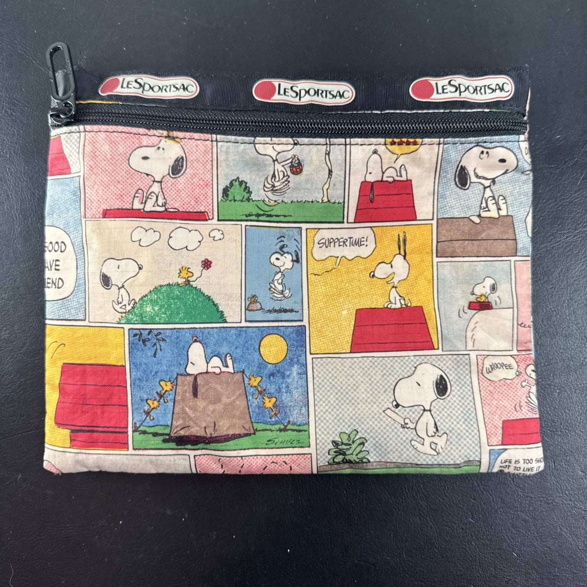LeSportsac x Peanuts Snoopy vintage comic strip cosmetic pouch with top zip and black trim.