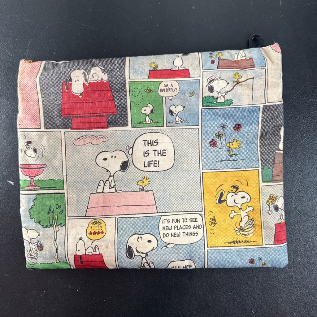 LeSportsac x Peanuts Snoopy vintage comic strip cosmetic pouch with top zip and black trim.