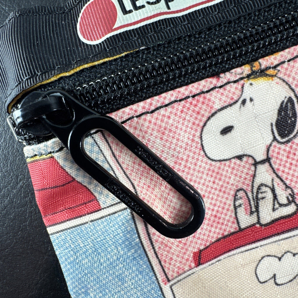 LeSportsac x Peanuts Snoopy vintage comic strip cosmetic pouch with top zip and black trim.