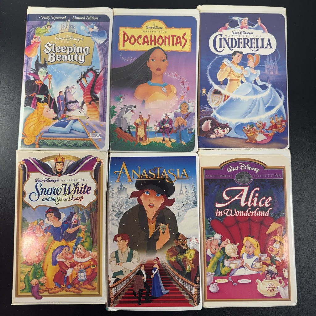 Set of 6 vintage Disney animated VHS tapes in original white clamshell cases including Cinderella and Sleeping Beauty.