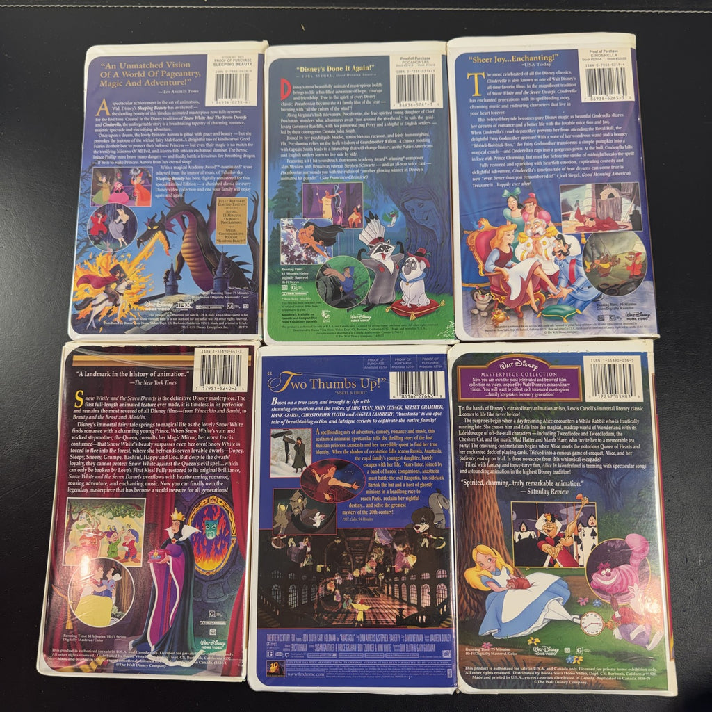 Set of 6 vintage Disney animated VHS tapes in original white clamshell cases including Cinderella and Sleeping Beauty.