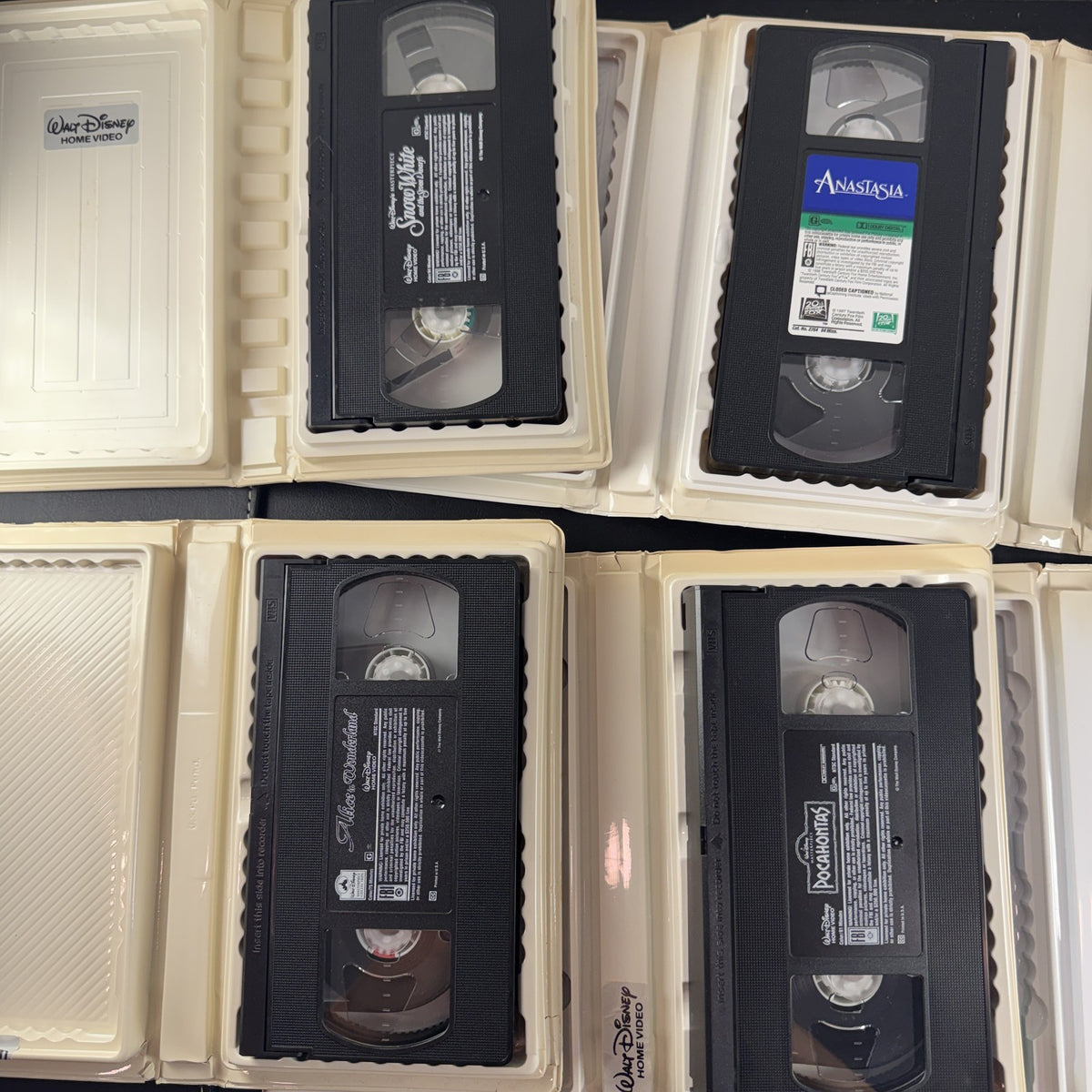 Set of 6 vintage Disney animated VHS tapes in original white clamshell cases including Cinderella and Sleeping Beauty.