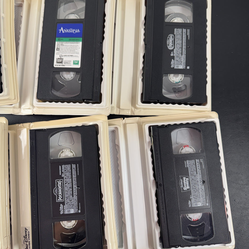 Set of 6 vintage Disney animated VHS tapes in original white clamshell cases including Cinderella and Sleeping Beauty.