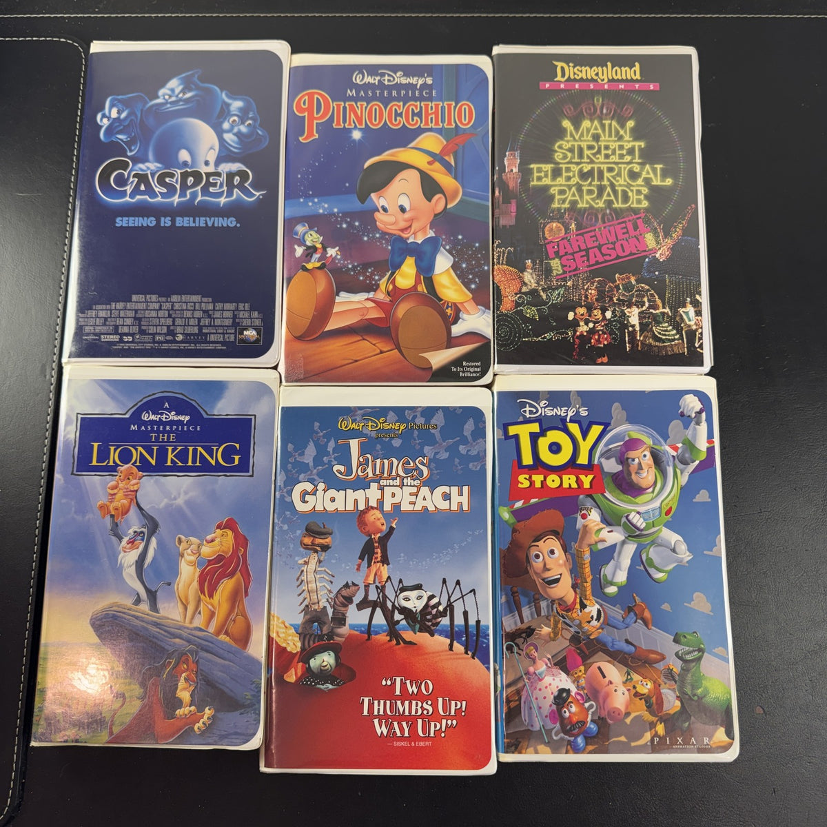 Set of 6 vintage Disney VHS tapes including Toy Story, Lion King, and Pinocchio in slipcases.