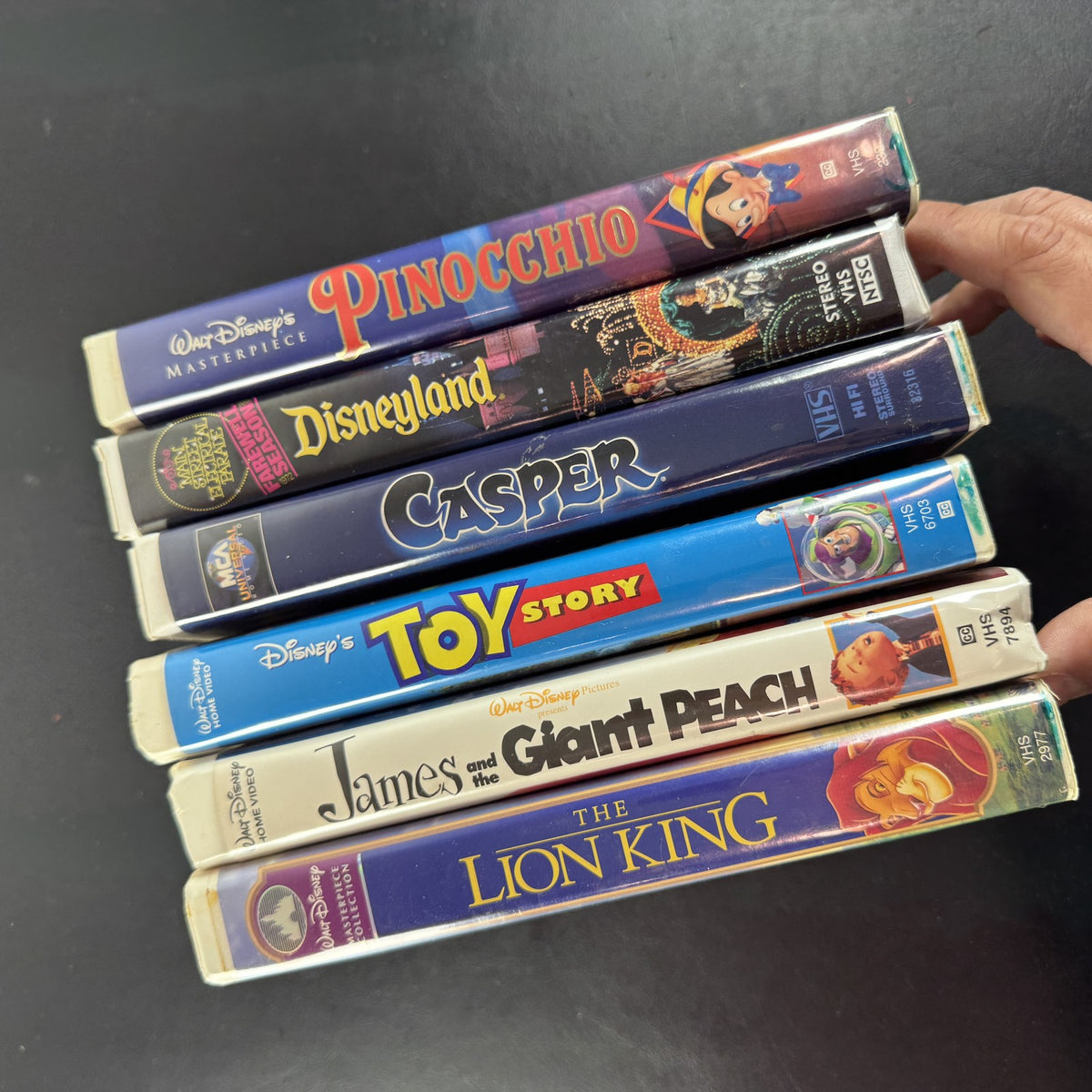 Set of 6 vintage Disney VHS tapes including Toy Story, Lion King, and Pinocchio in slipcases.