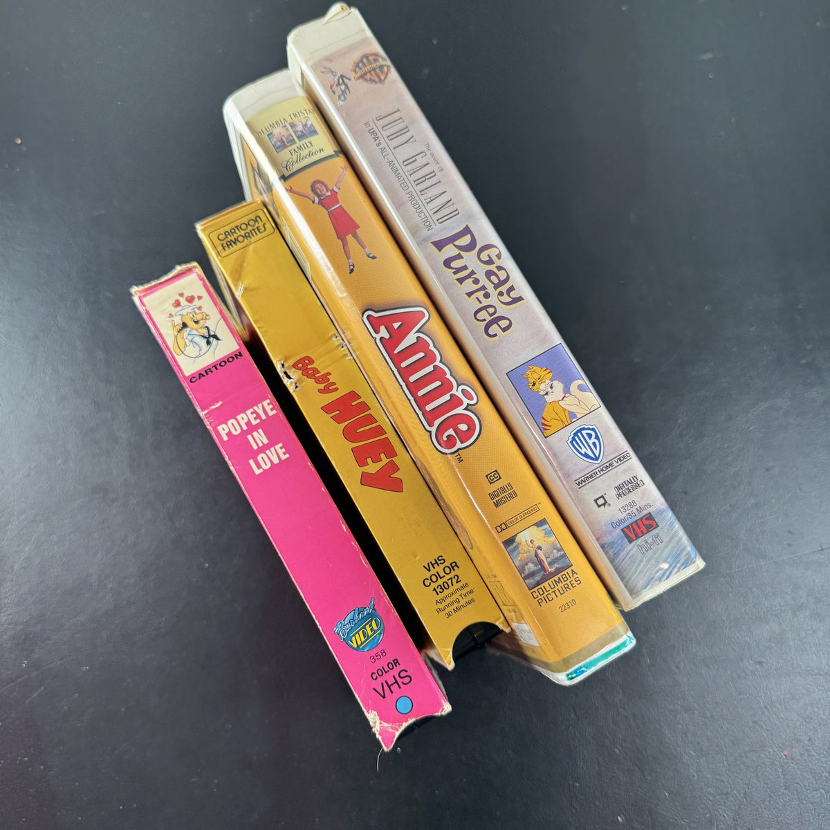 Bundle of 4 classic animated family movie VHS tapes including Annie, Gay Purr-ee, Popeye, and Baby Huey.