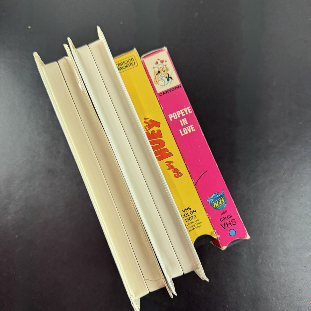 Bundle of 4 classic animated family movie VHS tapes including Annie, Gay Purr-ee, Popeye, and Baby Huey.