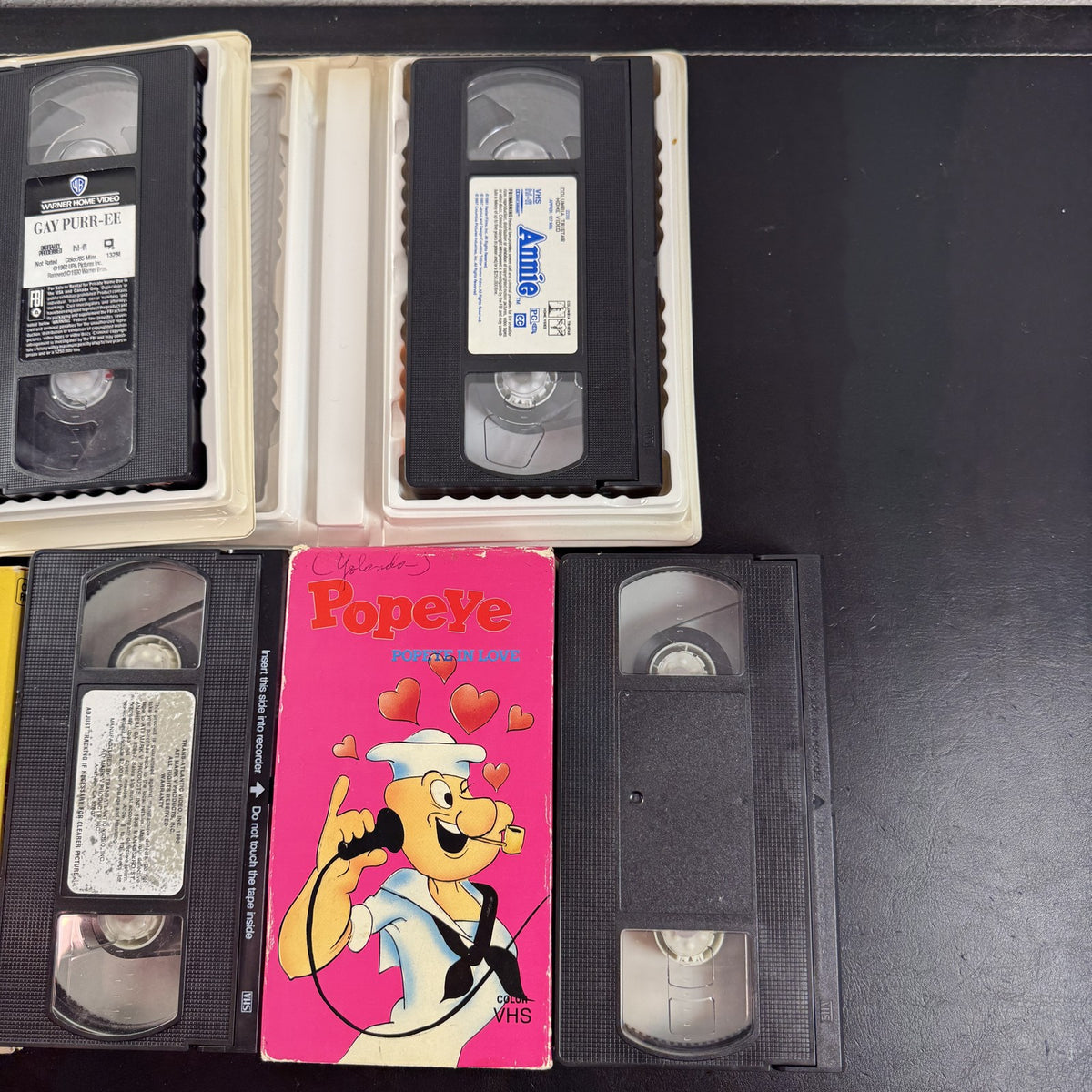 Bundle of 4 classic animated family movie VHS tapes including Annie, Gay Purr-ee, Popeye, and Baby Huey.