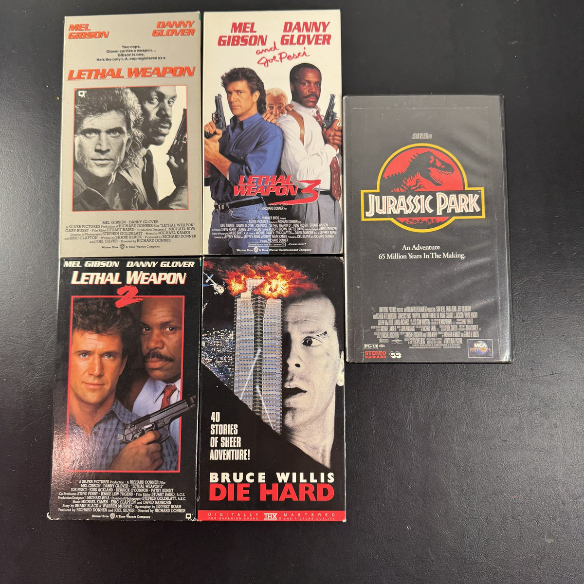 Lot of 5 classic action movie VHS tapes including Jurassic Park, Die Hard, and Lethal Weapon 1-3.