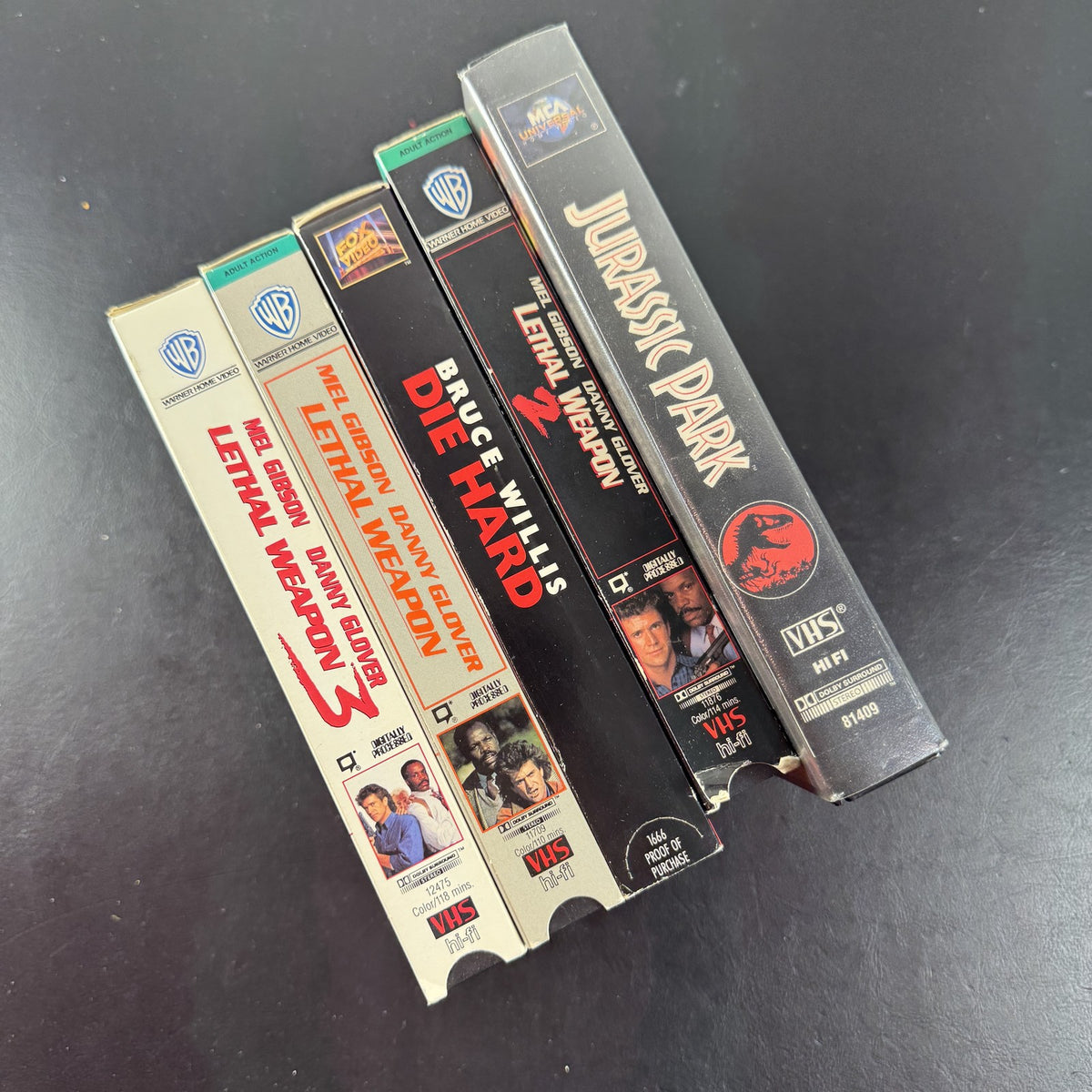 Lot of 5 classic action movie VHS tapes including Jurassic Park, Die Hard, and Lethal Weapon 1-3.