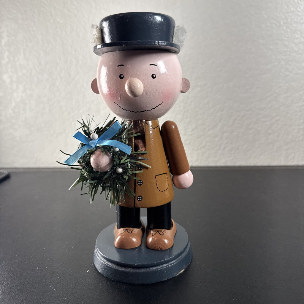 8-inch wooden Peanuts holiday nutcracker holding a Christmas wreath
