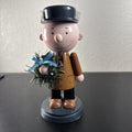 8-inch wooden Peanuts holiday nutcracker holding a Christmas wreath