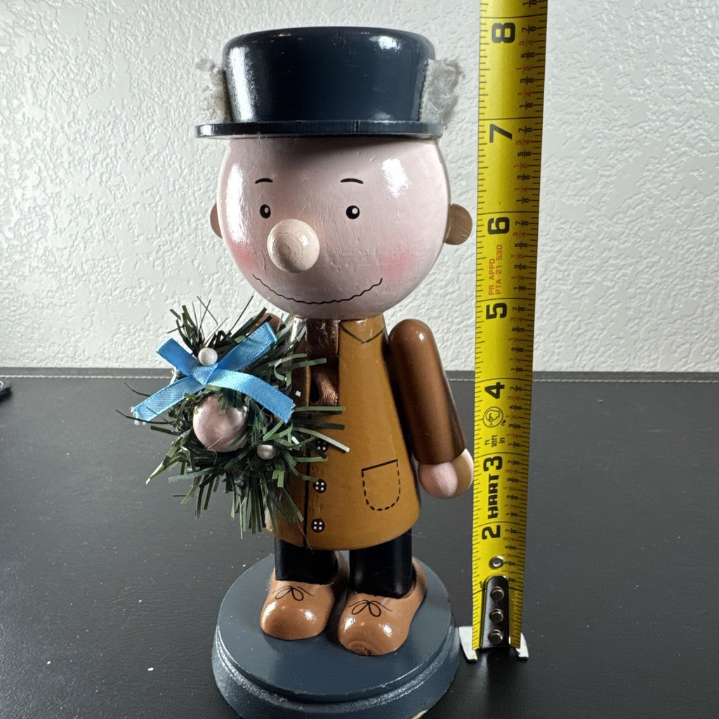 8-inch wooden Peanuts holiday nutcracker holding a Christmas wreath