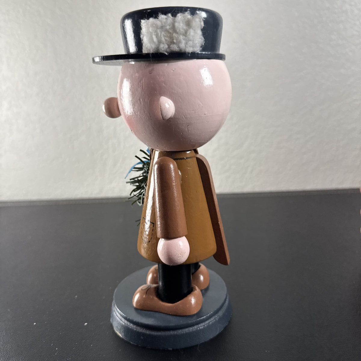 8-inch wooden Peanuts holiday nutcracker holding a Christmas wreath