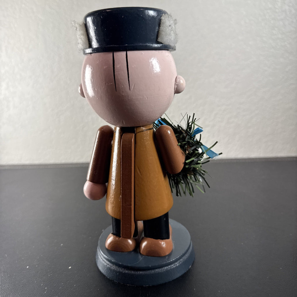 8-inch wooden Peanuts holiday nutcracker holding a Christmas wreath