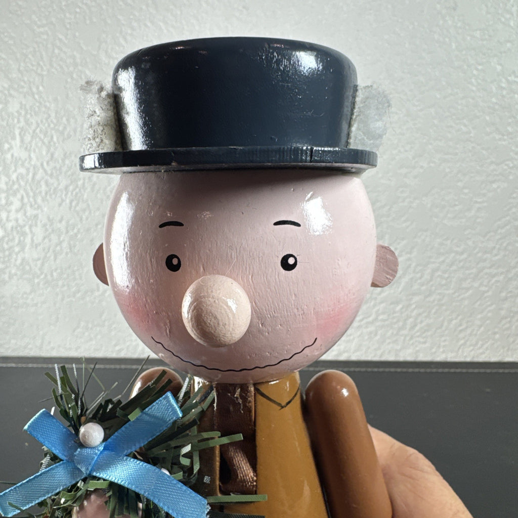 8-inch wooden Peanuts holiday nutcracker holding a Christmas wreath