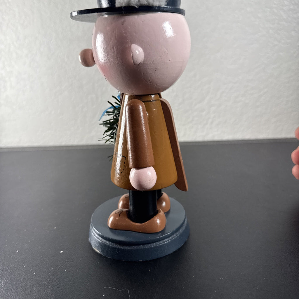 8-inch wooden Peanuts holiday nutcracker holding a Christmas wreath