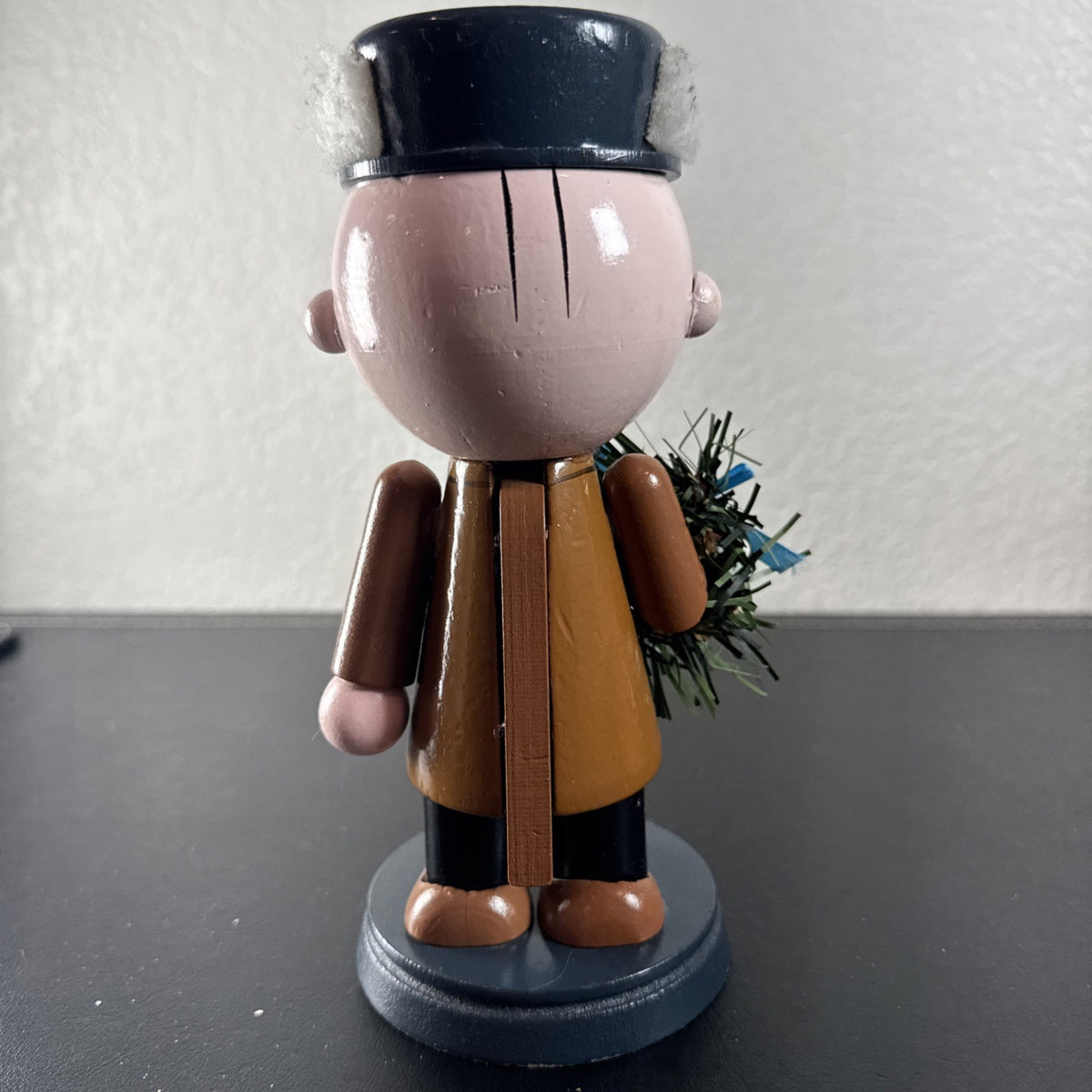 8-inch wooden Peanuts holiday nutcracker holding a Christmas wreath