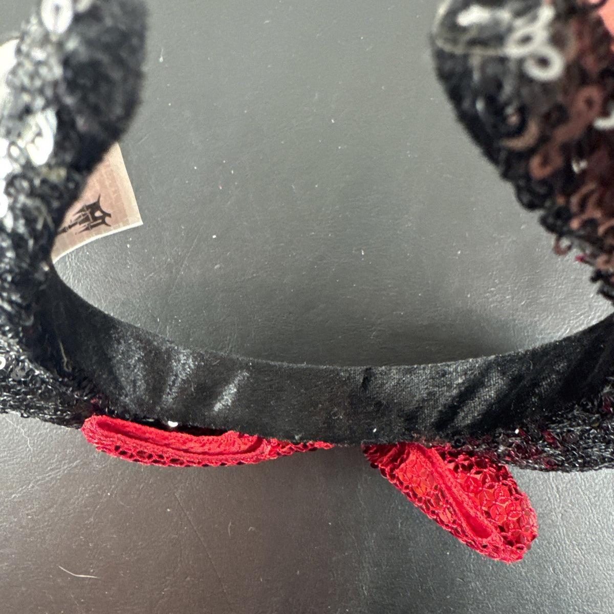 Disney Parks Minnie Mouse ears headband featuring a red sequined bow with gold accents.
