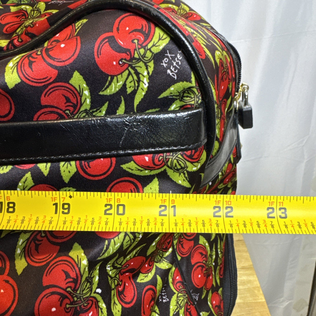 Betsey Johnson black rolling weekender duffel bag featuring a red cherry print and telescoping handle.