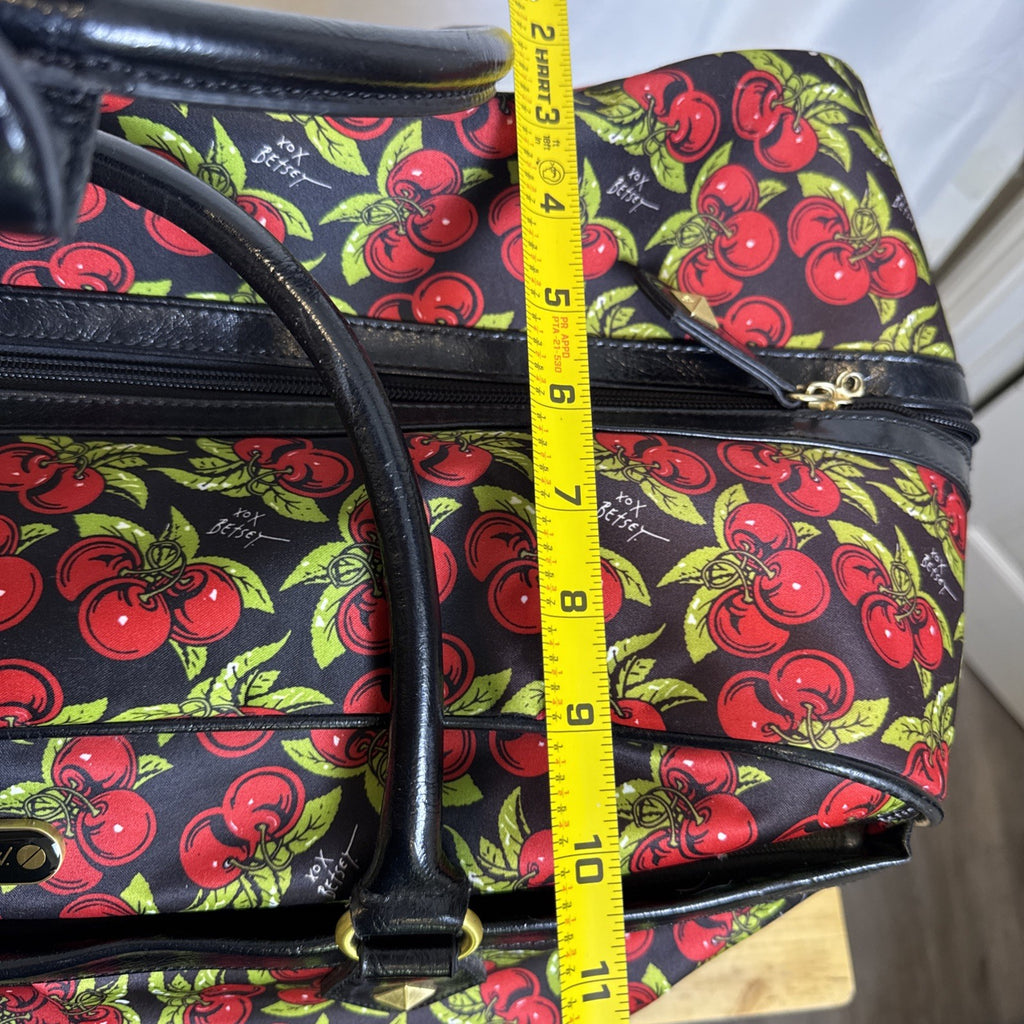 Betsey Johnson black rolling weekender duffel bag featuring a red cherry print and telescoping handle.