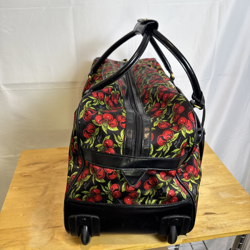 Betsey Johnson black rolling weekender duffel bag featuring a red cherry print and telescoping handle.