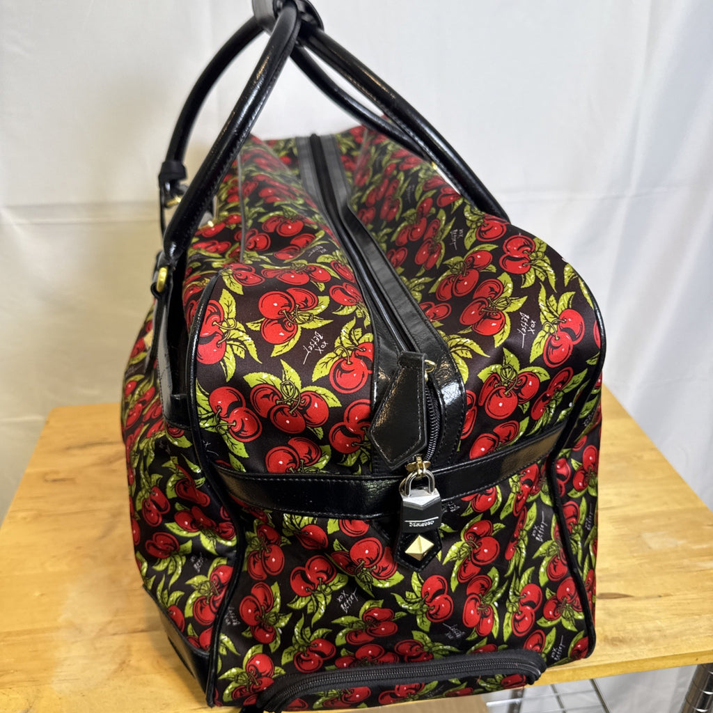 Betsey Johnson black rolling weekender duffel bag featuring a red cherry print and telescoping handle.