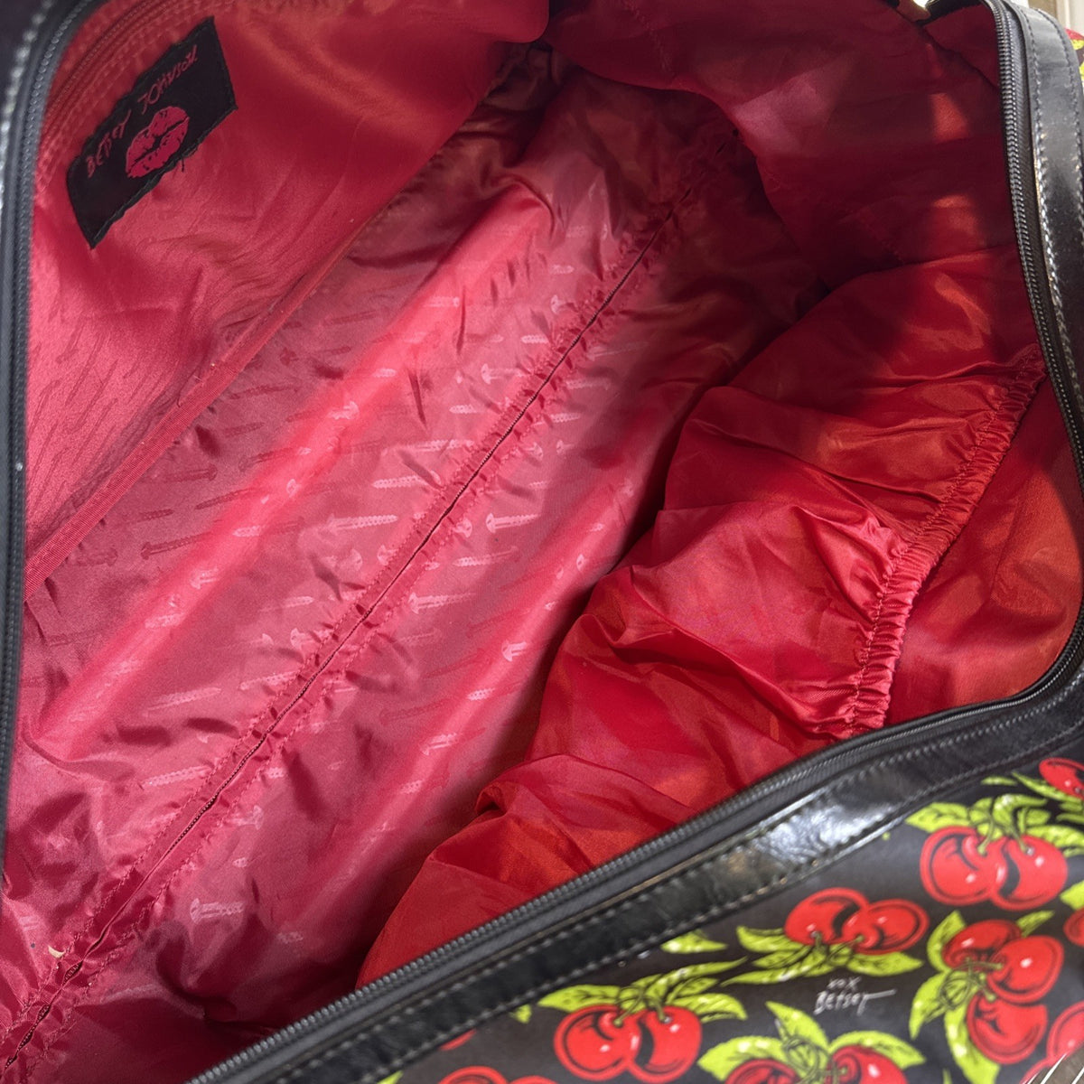 Betsey Johnson black rolling weekender duffel bag featuring a red cherry print and telescoping handle.