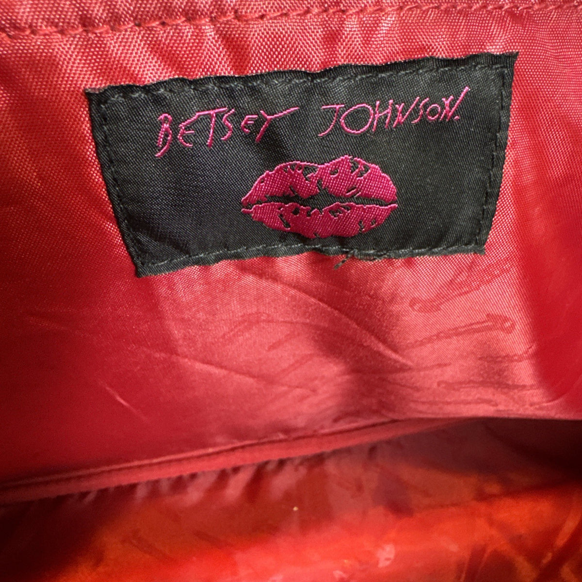 Betsey Johnson black rolling weekender duffel bag featuring a red cherry print and telescoping handle.