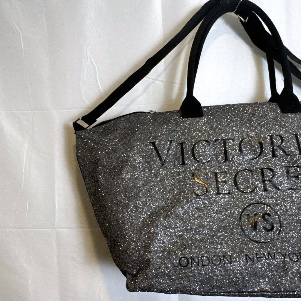 Victoria's Secret oversized silver glitter weekender tote bag with London New York Paris graphic and black canvas handles.