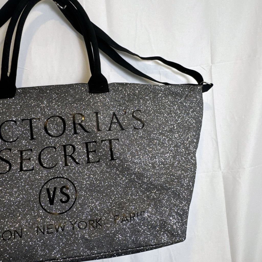 Victoria's Secret oversized silver glitter weekender tote bag with London New York Paris graphic and black canvas handles.