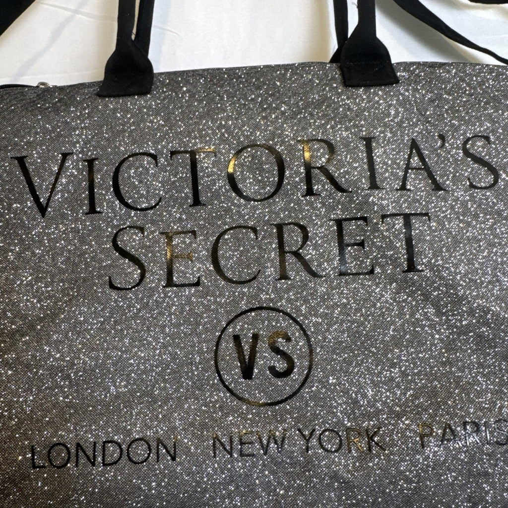 Victoria's Secret oversized silver glitter weekender tote bag with London New York Paris graphic and black canvas handles.