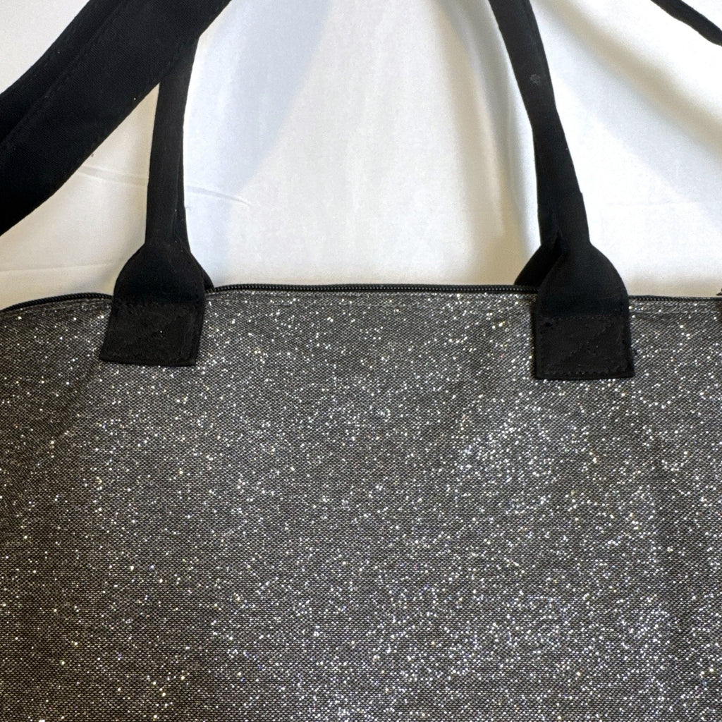 Victoria's Secret oversized silver glitter weekender tote bag with London New York Paris graphic and black canvas handles.
