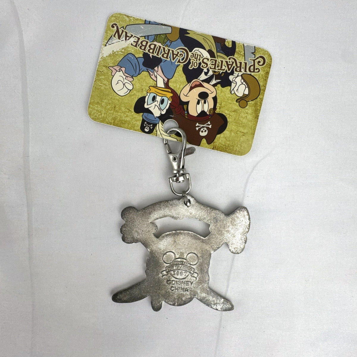 Disney 2007 Pirates of the Caribbean skull and crossed swords enamel lanyard medal clip on original backing card.